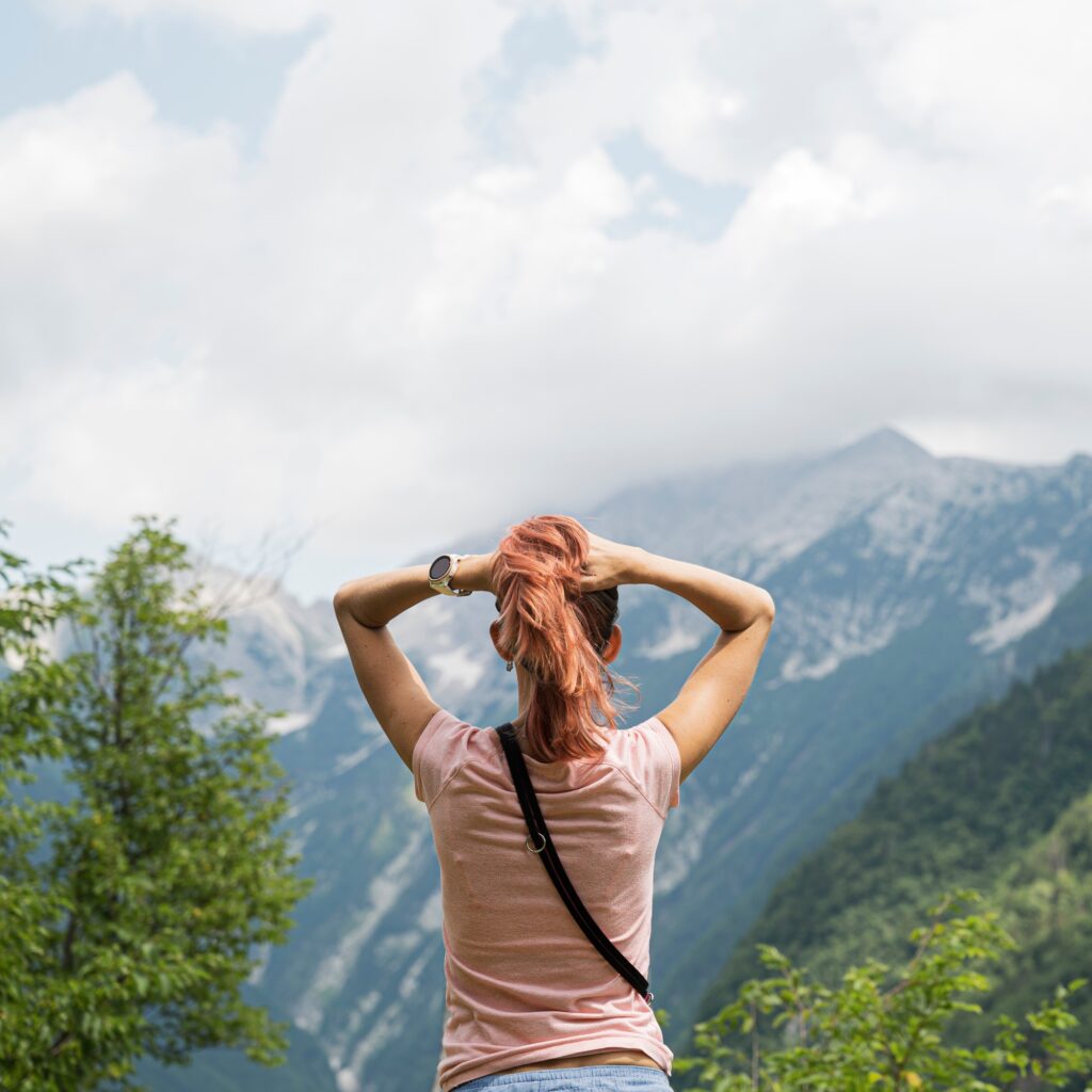 View from behind of a young woman enjoying in beautiful nature