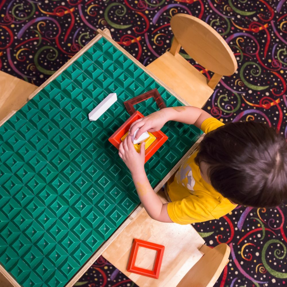 Overhead of Boy Playing With His Toys at Table